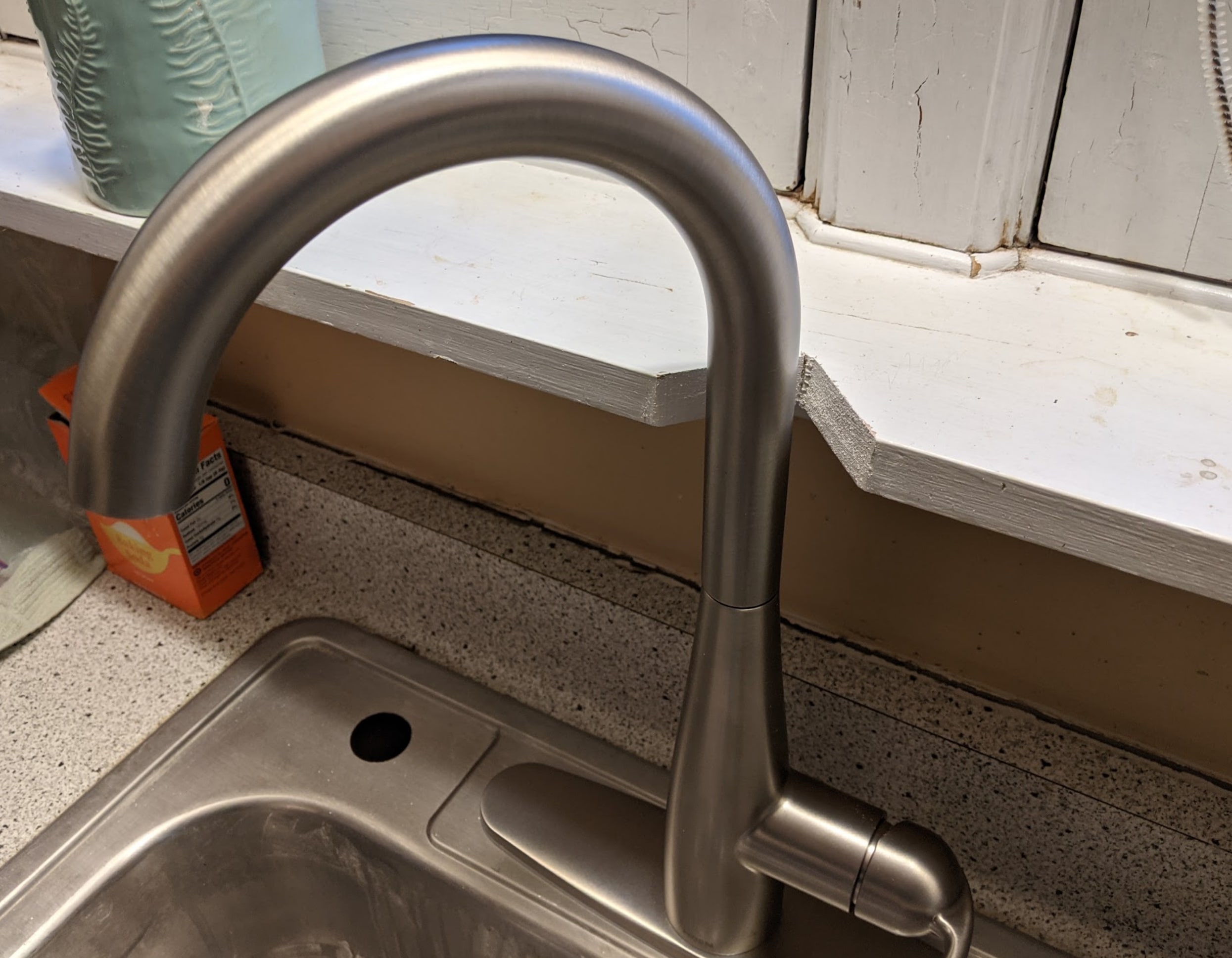 The kitchen faucet in place, with a notch cut into the shelf to make space.